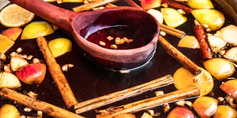 Un bol rempli de pommes, de bâtons de cannelle et de cannelle, accompagné de sauce érable.